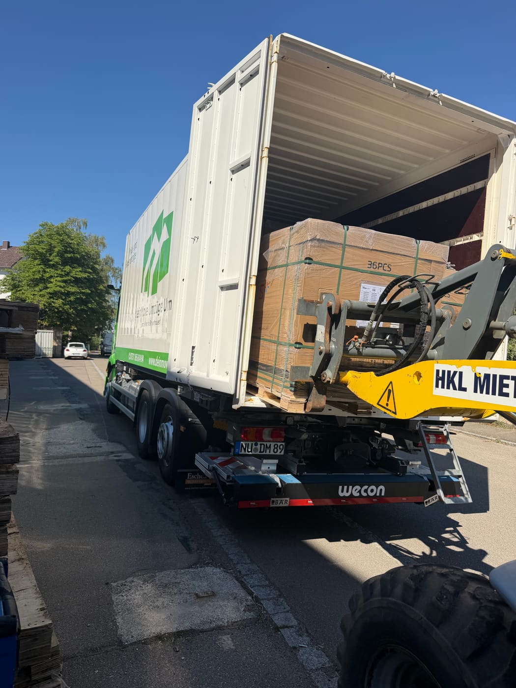 deinMove-LKW mit Ladekran verlädt palettiertes Baumaterial — Baustellenlogistik im Raum Ulm